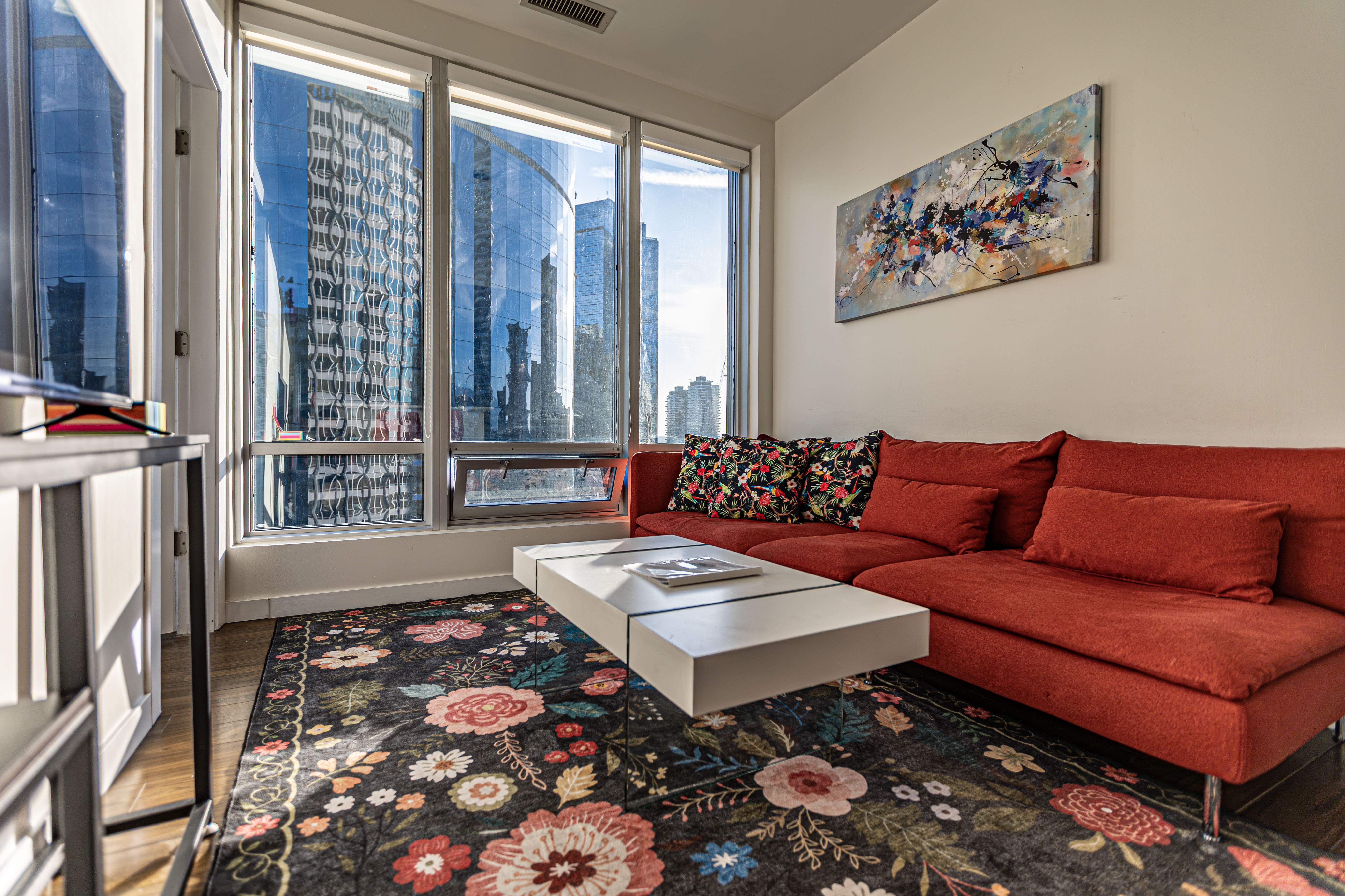 Coco Suite Vancouver living room with large windows and a red sofa